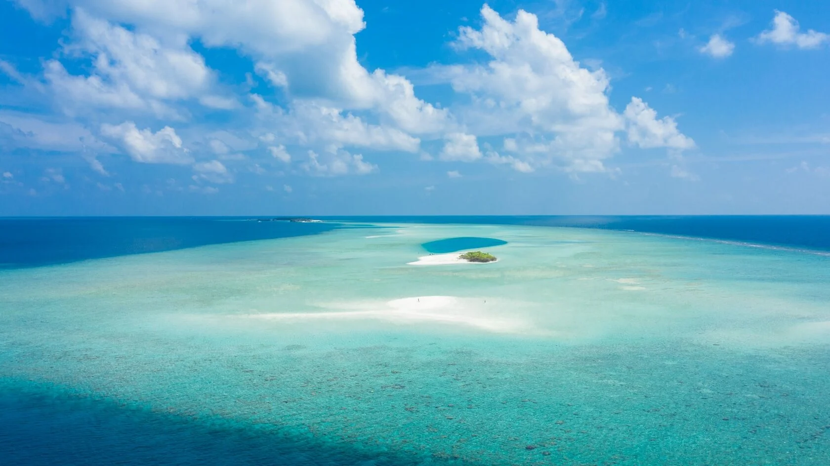 A white sandbank in a wide turquoise Maldivian lagoon